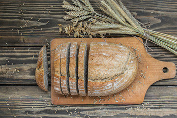 Fototapeta na wymiar Bread of a mixture of flour sliced on a wooden background