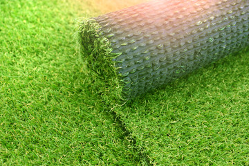 Artificial turf laying background. Roll of an synthenic grass layer. Greenering of the yard with an...