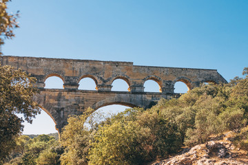 Fototapeta na wymiar Beautiful view of a fragment of the Pont du Gard in the fall against the blue sky