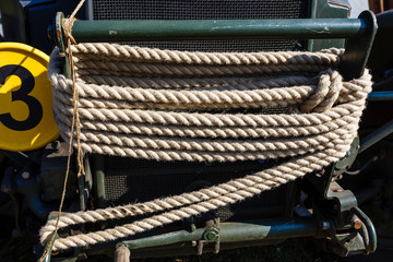 Towing rope is tightly wound on bumper of old military car.