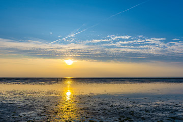 Spazierg&auml;nger im Wattenmeer bei Abendrot und Ebbe Nordsee Seutschland