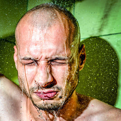 Fototapeta na wymiar A man gives himself a cold shower after work to calm down after hard frustrated and nervous day at his job close up