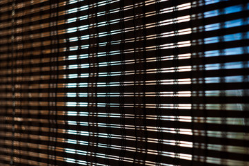 The interior of the home, sunlight shining through the bamboo blinds at the window.