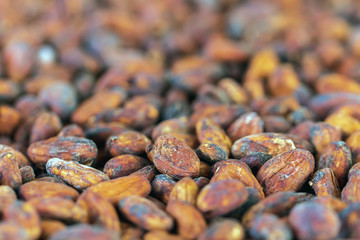Cocoa beans and cocoa pod on a wooden surface.