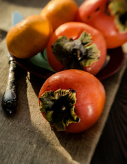 Bright juicy persimmon on the background of a wooden table. Winter fruits