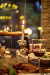 glass of red wine and candle on wooden table