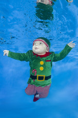 Little boy dressed as a gnome underwater on a blue water background.  Healthy family lifestyle and...