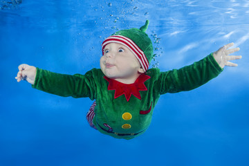 Little boy dressed as a gnome underwater on a blue water background.  Healthy family lifestyle and...