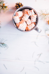 Marshmallow in an iron cup on a white wooden background