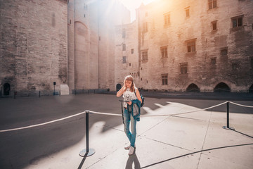 Pleasant nice attractive blonde girl in the courtyard of a medieval castle