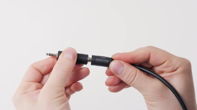 Hand holding RCA Audio jack cable 3.5mm isolated on white background adapter aux