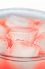 Orange drink closeup with ice cubes background