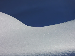 Unberührte glitzernde Schneedecke unter dunkelblauem HImmel