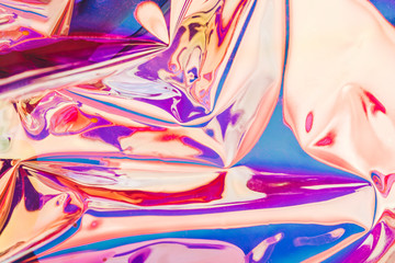 Bright holographic foil background. Multicolored and pastel trendy backdrop.