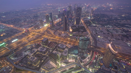Obraz premium Dubai downtown from day to night transition with city lights from Burj Khalifa timelapse