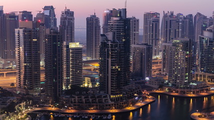 Fototapeta na wymiar Dubai marina harbor from night to day transition timelapse close view