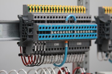 Connecting through-pass electrical terminals in the electrical panel