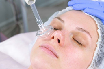 Obraz na płótnie Canvas Beauty treatment facial electric darsonval therapy at cosmetology clinic.