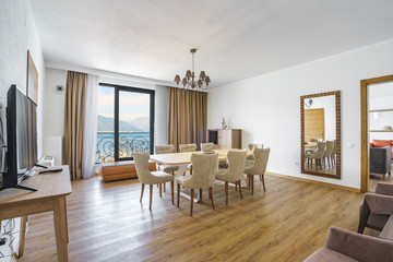 Fototapeta premium Interior of light spacious living room with a picturesque mountain and sea view in a luxury villa