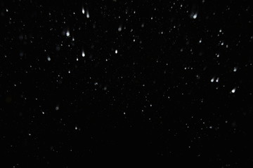 The texture of the flying snow on a black background.