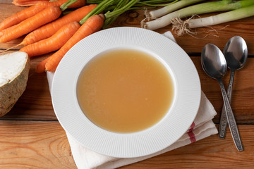 Chicken bone broth in a plate, top view