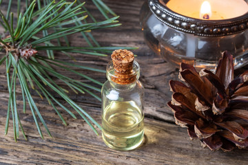A bottle of pine essential oil with fresh pine branches
