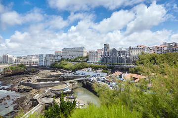 Fototapeta na wymiar Cityscape of Biarritz, France: Old stone harbor, buildings and church on the hill