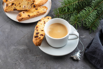 Traditional Christmas pastries, Italian homemade double-baked biscotti or cantuccini cake with coffee, with nuts and dried fruits. with xmas decorations and fir branches.