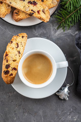 Traditional Christmas pastries, Italian homemade double-baked biscotti or cantuccini cake with coffee, with nuts and dried fruits. with xmas decorations and fir branches.