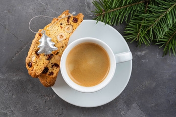 Traditional Christmas pastries, Italian homemade double-baked biscotti or cantuccini cake with coffee, with nuts and dried fruits. with xmas decorations and fir branches.