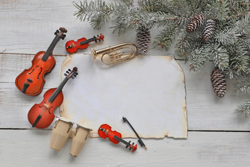 Christmas tree branches with music instruments on wooden background 