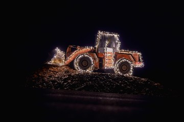 Blurred wheel loader decorated with lights in winter