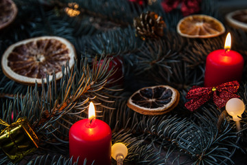 Christmas background with fir and citrus, as well as red candles and decorations