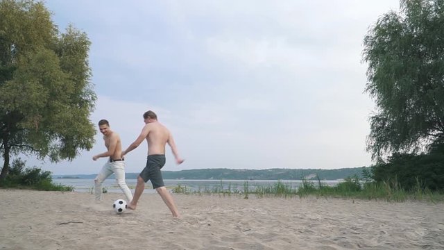 Two young guys playing football Competition between people Friends have a fun together Spending time outdoors Active lifestyle