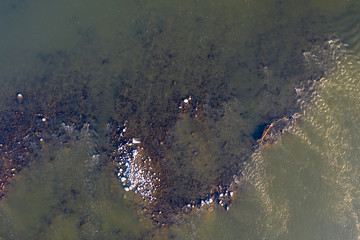 kamienie i pień drzewa w rzece o zachodzie słońca widok od góry © Arkadiusz