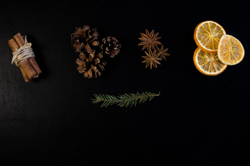 Christmas Tree Pine Branches with dry oranges. cinnamon, anise, pine on a dark background.