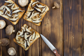 Sandwiches with mushrooms shiitake on the brown wooden background.Top view.Copy space.Healthy food ingredients.