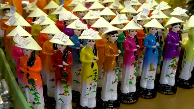 Vietnamese women china figurines, wearing traditional female clothing, for sale in Saigon market, Vietnam