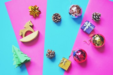 Flat lay Christmas decoration. Balls, wooden horse, pine cones, origami tree. New Year holidays