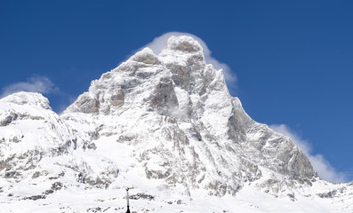 Motterhorn iluminated by the direct sun reflecting the white snow surrounded by the blue sky