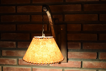 turning on an antique lamp on a red brick wall in a dark room