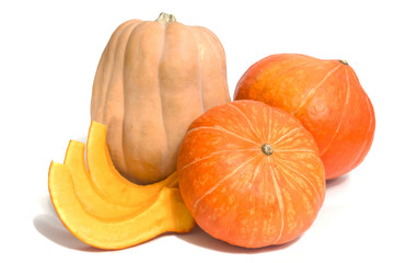 Two orange and one yellow pumpkins with three slices isolated on white