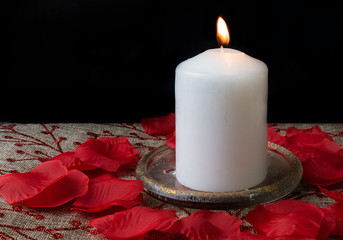 One white candle on rustic background.