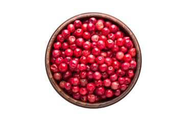 pink peppercorn spice in wooden bowl, isolated on white background. Seasoning top view