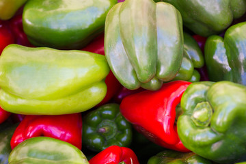 Close up on green and red bell peppers. Fresh, organic vegetables on market stall. Vegetarian healthy food