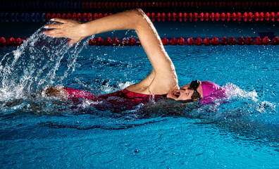 Woman in swimming pool. Crawl swimming style