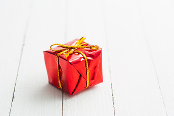 Red gift box on white wood