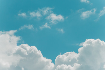 White fluffy clouds in turquoise blue sky. Copy space. Vintage colors. For background and wallpaper