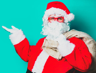 Fototapeta na wymiar Funny Santa Claus have a fun with red eyeglasses on green background