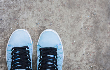 Sneakers of blue suede on the sidewalk